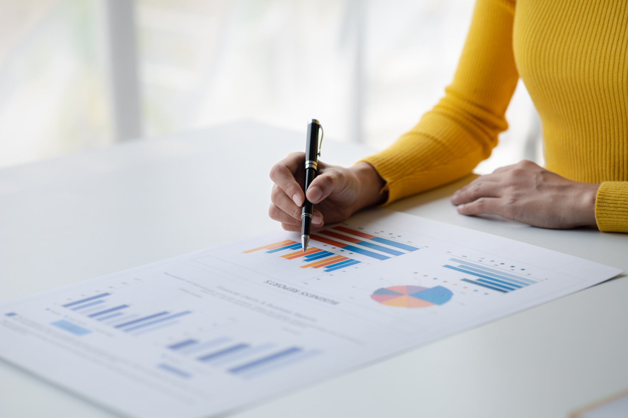 A female financier is reviewing company financial documents, monthly financial statement summary.