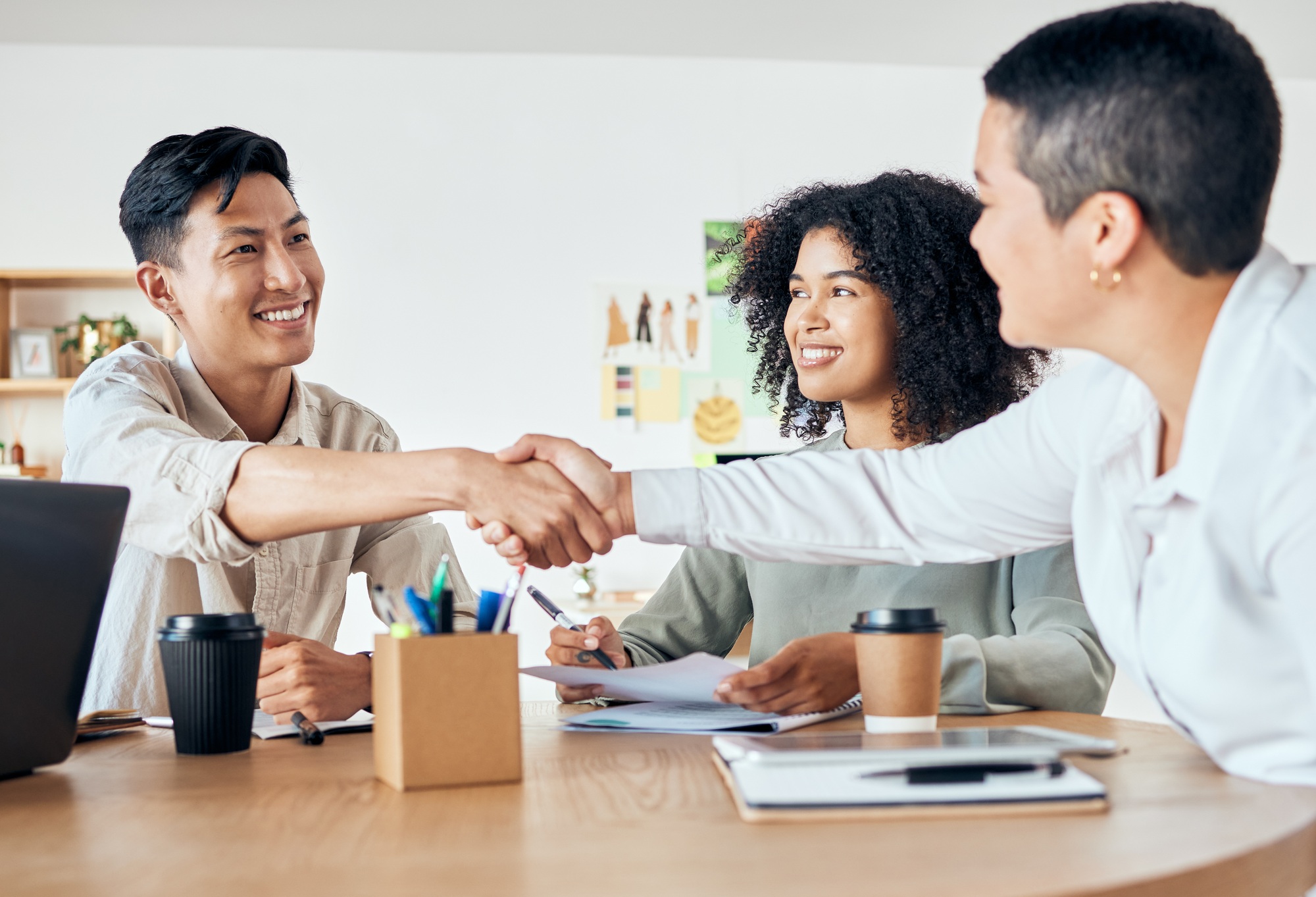 Handshake, global partnership and office deal in business meeting with man and women for diversity